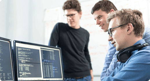 Coworkers looking through code on a computer